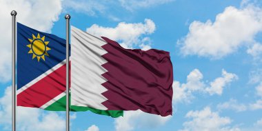 Namibya ve Katar bayrağı birlikte beyaz bulutlu mavi gökyüzüne karşı rüzgarda sallayarak. Diplomasi kavramı, uluslararası ilişkiler.