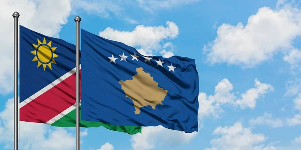 Bandera de Namibia y Kosovo ondeando en el viento contra el cielo azul nublado blanco juntos. Concepto diplomático, relaciones internacionales . — Foto de Stock