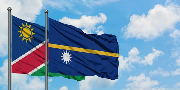 Bandera de Namibia y Nauru ondeando en el viento contra el cielo azul nublado blanco juntos. Concepto diplomático, relaciones internacionales . — Foto de Stock