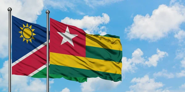 Namibia and Togo flag waving in the wind against white cloudy blue sky together. Diplomacy concept, international relations. — Stock Photo, Image