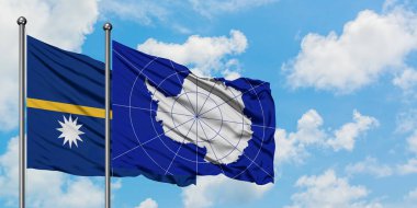 Nauru ve Antarktika bayrağı birlikte beyaz bulutlu mavi gökyüzüne karşı rüzgarda sallayarak. Diplomasi kavramı, uluslararası ilişkiler.