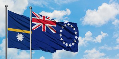 Nauru ve Cook Adaları bayrağı birlikte beyaz bulutlu mavi gökyüzüne karşı rüzgarda sallayarak. Diplomasi kavramı, uluslararası ilişkiler.