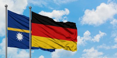 Nauru ve Almanya bayrağı birlikte beyaz bulutlu mavi gökyüzüne karşı rüzgarda sallayarak. Diplomasi kavramı, uluslararası ilişkiler.