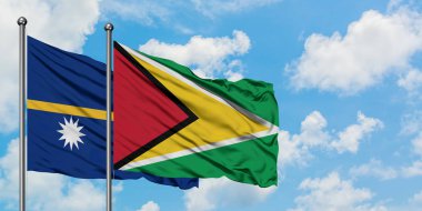 Nauru ve Guyana bayrağı birlikte beyaz bulutlu mavi gökyüzüne karşı rüzgarda sallayarak. Diplomasi kavramı, uluslararası ilişkiler.