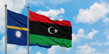 Nauru ve Libya bayrağı birlikte beyaz bulutlu mavi gökyüzüne karşı rüzgarda sallayarak. Diplomasi kavramı, uluslararası ilişkiler.