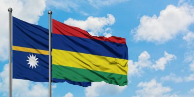 Nauru ve Mauritius bayrağı birlikte beyaz bulutlu mavi gökyüzüne karşı rüzgarda sallayarak. Diplomasi kavramı, uluslararası ilişkiler.