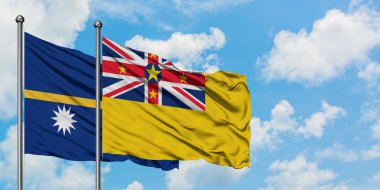 Nauru ve Niue bayrağı birlikte beyaz bulutlu mavi gökyüzüne karşı rüzgarda sallayarak. Diplomasi kavramı, uluslararası ilişkiler.