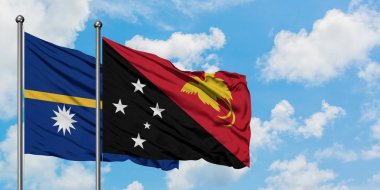 Nauru ve Papua Yeni Gine bayrağı birlikte beyaz bulutlu mavi gökyüzüne karşı rüzgarda sallayarak. Diplomasi kavramı, uluslararası ilişkiler.