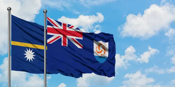 나우루와 앵귈라 깃발이 하얀 흐린 푸른 하늘을 배경으로 바람에 흔들리고 있습니다. 외교 개념, 국제 관계. — 스톡 사진