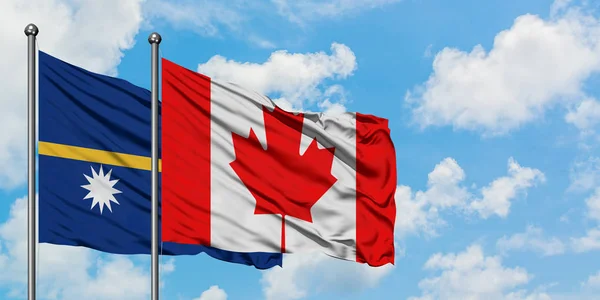 Bandera de Nauru y Canadá ondeando en el viento contra el cielo azul nublado blanco juntos. Concepto diplomático, relaciones internacionales . — Foto de Stock