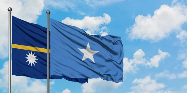 Bandera de Nauru y Somalia ondeando en el viento contra el cielo azul nublado blanco juntos. Concepto diplomático, relaciones internacionales . —  Fotos de Stock