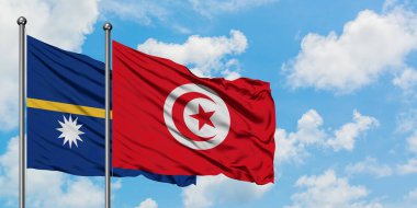 Nauru ve Tunus bayrağı birlikte beyaz bulutlu mavi gökyüzüne karşı rüzgarda sallayarak. Diplomasi kavramı, uluslararası ilişkiler.