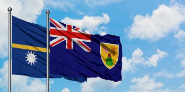 Nauru ve Turks ve Caicos Adaları bayrağı birlikte beyaz bulutlu mavi gökyüzüne karşı rüzgarda sallayarak. Diplomasi kavramı, uluslararası ilişkiler.