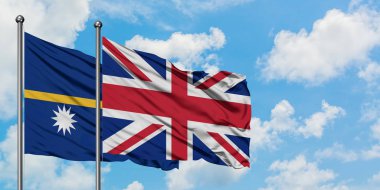 Nauru ve Birleşik Krallık bayrağı birlikte beyaz bulutlu mavi gökyüzüne karşı rüzgarda sallayarak. Diplomasi kavramı, uluslararası ilişkiler.