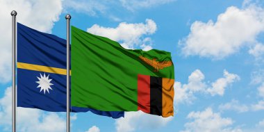 Nauru ve Zambiya bayrağı birlikte beyaz bulutlu mavi gökyüzüne karşı rüzgarda sallayarak. Diplomasi kavramı, uluslararası ilişkiler.