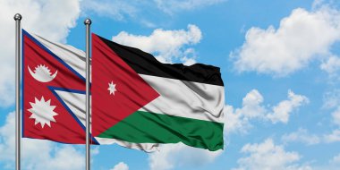 Nepal ve Ürdün bayrağı birlikte beyaz bulutlu mavi gökyüzüne karşı rüzgarda sallayarak. Diplomasi kavramı, uluslararası ilişkiler.