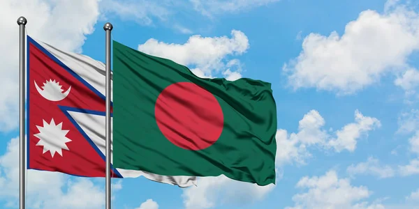 Bandera de Nepal y Bangladesh ondeando en el viento contra el cielo azul nublado blanco juntos. Concepto diplomático, relaciones internacionales . — Foto de Stock