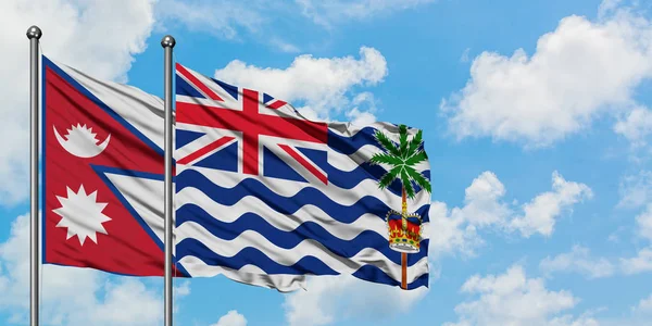 尼泊尔和英属印度洋地区国旗在风中飘扬，白云蓝天相聚。外交概念、国际关系. — 图库照片