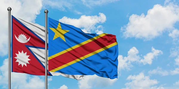 Bandera de Nepal y Congo ondeando en el viento contra el cielo azul nublado blanco juntos. Concepto diplomático, relaciones internacionales . — Foto de Stock