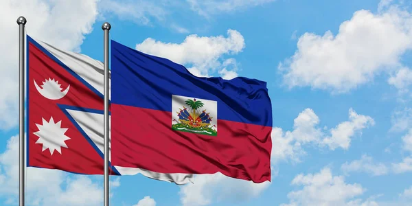 Nepal and Haiti flag waving in the wind against white cloudy blue sky together. Diplomacy concept, international relations. — Stock Photo, Image