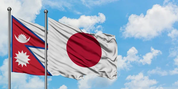Nepal ve Japonya bayrağı birlikte beyaz bulutlu mavi gökyüzüne karşı rüzgarda sallayarak. Diplomasi kavramı, uluslararası ilişkiler. — Stok fotoğraf