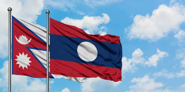 Nepal ve Laos bayrağı birlikte beyaz bulutlu mavi gökyüzüne karşı rüzgarda sallayarak. Diplomasi kavramı, uluslararası ilişkiler. — Stok fotoğraf