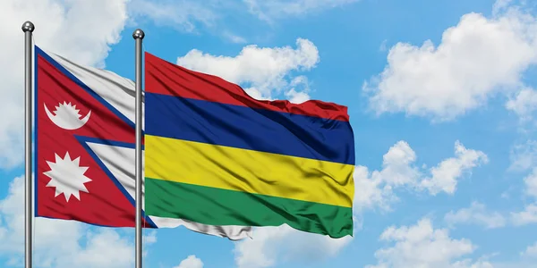 Bandera de Nepal y Mauricio ondeando en el viento contra el cielo azul nublado blanco juntos. Concepto diplomático, relaciones internacionales . — Foto de Stock