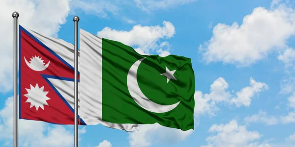 Nepal and Pakistan flag waving in the wind against white cloudy blue sky together. Diplomacy concept, international relations. — Stock Photo, Image