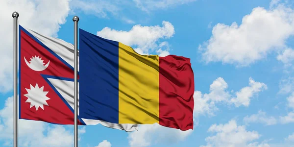 Bandera de Nepal y Rumanía ondeando en el viento contra el cielo azul nublado blanco juntos. Concepto diplomático, relaciones internacionales . — Foto de Stock