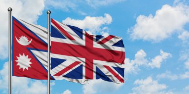 Nepal ve Birleşik Krallık bayrağı birlikte beyaz bulutlu mavi gökyüzüne karşı rüzgarda sallayarak. Diplomasi kavramı, uluslararası ilişkiler.