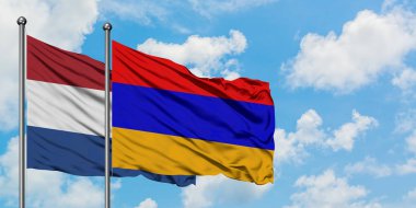 Hollanda ve Ermenistan bayrağı birlikte beyaz bulutlu mavi gökyüzüne karşı rüzgarsal sallayarak. Diplomasi kavramı, uluslararası ilişkiler.