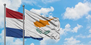 Hollanda ve Kıbrıs bayrağı birlikte beyaz bulutlu mavi gökyüzüne karşı rüzgarsal sallayarak. Diplomasi kavramı, uluslararası ilişkiler.