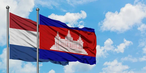 Paesi Bassi e Cambogia bandiera sventolando nel vento contro bianco cielo blu nuvoloso insieme. Concetto di diplomazia, relazioni internazionali . — Foto Stock
