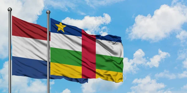 Bandera de los Países Bajos y República Centroafricana ondeando en el viento contra el cielo azul nublado blanco juntos. Concepto diplomático, relaciones internacionales . — Foto de Stock
