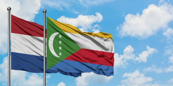 Bandera de Holanda y Comoras ondeando en el viento contra el cielo azul nublado blanco juntos. Concepto diplomático, relaciones internacionales . — Foto de Stock