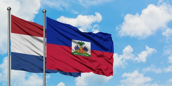 Нідерланди і Гаїті прапор розмахуючи в вітру проти білого хмарного синього неба разом. Концепція дипломатії, міжнародні відносини. — стокове фото