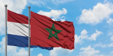 Netherlands and Morocco flag waving in the wind against white cloudy blue sky together. Diplomacy concept, international relations. clipart