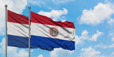 Hollanda ve Paraguay bayrağı birlikte beyaz bulutlu mavi gökyüzüne karşı rüzgarsal sallayarak. Diplomasi kavramı, uluslararası ilişkiler.