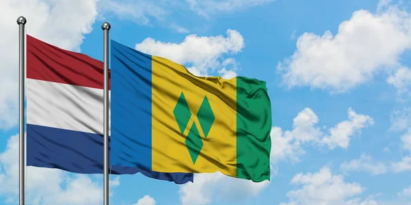 Netherlands and Saint Vincent And The Grenadines flag waving in the wind against white cloudy blue sky together. Diplomacy concept, international relations. — Stock Photo, Image