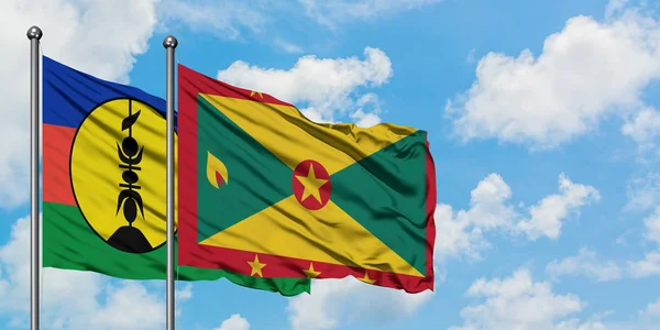 Bandera de Nueva Caledonia y Granada ondeando en el viento contra el cielo azul nublado blanco juntos. Concepto diplomático, relaciones internacionales . — Foto de Stock