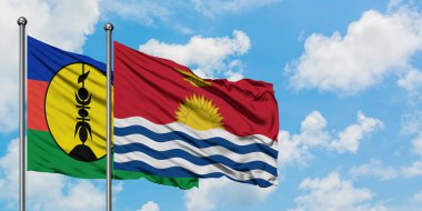 Yeni Kaledonya ve Kiribati bayrağı birlikte beyaz bulutlu mavi gökyüzüne karşı rüzgarda sallayarak. Diplomasi kavramı, uluslararası ilişkiler.