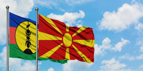 Nova Caledónia e Macedónia acenando ao vento contra o céu azul nublado branco juntos. Conceito de diplomacia, relações internacionais . — Fotografia de Stock