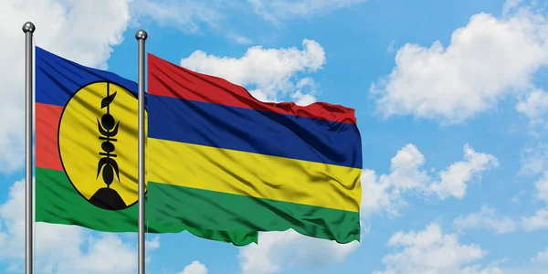 Bandera de Nueva Caledonia y Mauricio ondeando en el viento contra el cielo azul nublado blanco juntos. Concepto diplomático, relaciones internacionales . — Foto de Stock