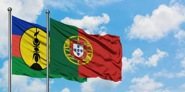 Nova Caledônia e bandeira de Portugal agitando no vento contra o céu azul nublado branco juntos. Conceito de diplomacia, relações internacionais . — Fotografia de Stock