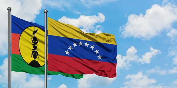 New Caledonia and Venezuela flag waving in the wind against white cloudy blue sky together. Diplomacy concept, international relations. — Stock Photo, Image