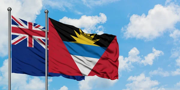 Yeni Zelanda ve Antigua ve Barbuda bayrağı birlikte beyaz bulutlu mavi gökyüzüne karşı rüzgarda sallayarak. Diplomasi kavramı, uluslararası ilişkiler. — Stok fotoğraf