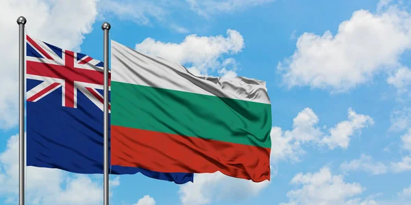 Bandera de Nueva Zelanda y Bulgaria ondeando en el viento contra el cielo azul nublado blanco juntos. Concepto diplomático, relaciones internacionales . — Foto de Stock