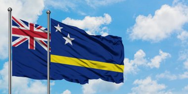 Yeni Zelanda ve Curacao bayrağı birlikte beyaz bulutlu mavi gökyüzüne karşı rüzgarda sallayarak. Diplomasi kavramı, uluslararası ilişkiler.