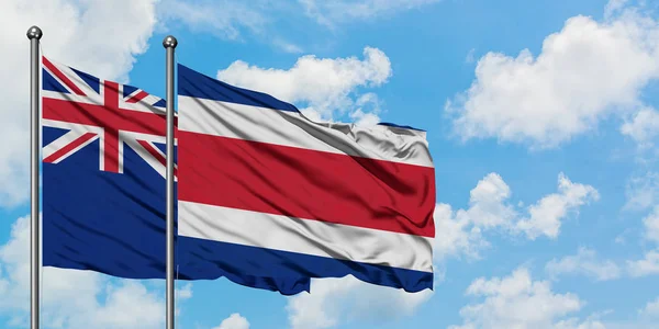 Nuova Zelanda e Costa Rica bandiera sventolando nel vento contro bianco cielo blu nuvoloso insieme. Concetto di diplomazia, relazioni internazionali . — Foto Stock