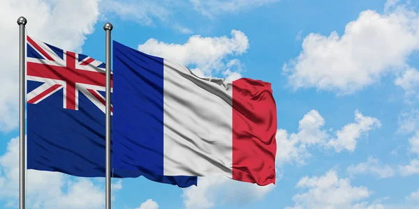 Bandera de Nueva Zelanda y Francia ondeando en el viento contra el cielo azul nublado blanco juntos. Concepto diplomático, relaciones internacionales . —  Fotos de Stock